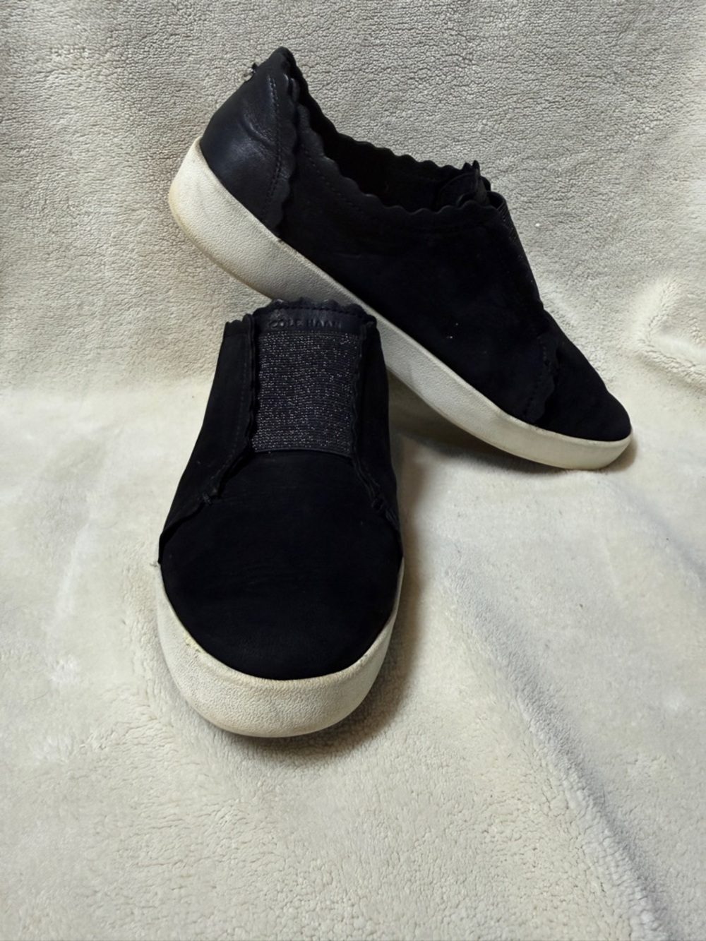 Cole Haan Black Slip-On Sneakers with White Sole and Scalloped Edge